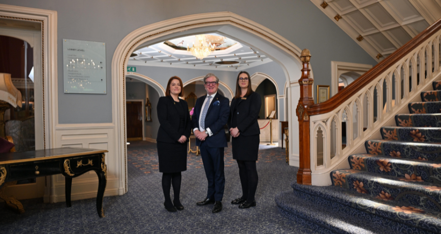 Culloden Estate and Spa staff beside a grand staircase in the hotel